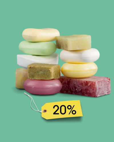 A pile of coloured bars of soap on a green background with a label saying 20%